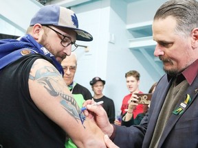 Felix Potvin autographs a tattoo of himself on Leafs superfan Jim Stefanko's arm in Sudbury on Tuesday afternoon. Potvin is in Sudbury coaching the midget AAA Magog Cantonniers at the Telus Cup. Gino Donato/The Sudbury Star/Postmedia Network