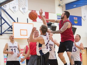 Jordan Remple with the PVR team, made up of current and former Canmore locals, jumps above a Camrose Trojans player, at the Over-35 Peaks basketball tournament at Lawrence Grassi Middle school on Saturday. The Trojans won 73-43 as PVR lost all three games they played on the weekend, opening with a 72-44 loss to Baseline and finishing the weekend with 46-39 loss to Stoney. Pam Doyle/ pamdoylephoto.com