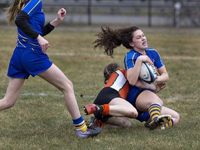 Arden Leschuck of Brantford Collegiate Institute is tackled by a North Park Collegiate player during a high school senior girls rugby match on Wednesday at Tollgate Field. (Brian Thompson/The Expositor)