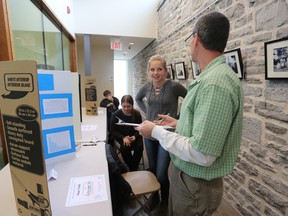 Mike Sewell, a judge for the County Kidpreneur Fair, talks with Pearl Monk about her business plan during the inaugural County Kidpreneur Fair event in Napanee on April 25. (Meghan Balogh/The Whig-Standard)