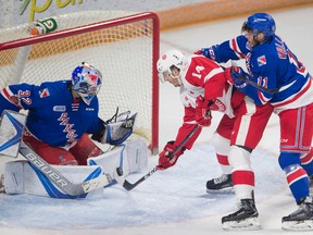 Peter Lee The Waterloo Record
Taylor Raddysh is checked by Rangers Giovanni Vallati, right, as Rangers goalie Mario Culina, left, stops a shot in OHL action at the Aud in Kitchener.