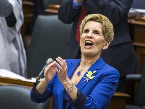 Ontario Premier Kathleen Wynne applauds while Ontario Finance Minister Charles Sousa (not shown) delivers the provincial budget at the Ontario Legislature on March 28. The budget included a deficit said to be $6.7 billion. The Ontario Liberals have rarely introduced a balanced budget since first elected 15 years ago. Ernest Doroszuk/Postmedia Network