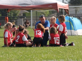 Jason Kaspersma, Strathroy United FC’s vice president, talks during a game to a group of girls members of the club. Supplied photo.