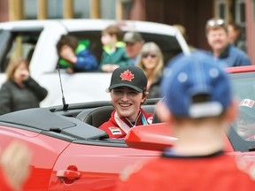 Paralympic silver medalist James Dunn drives by crowds on Main Street in Dutton for a parade in his honour on Saturday. (Tom Morrison/Chatham This Week)