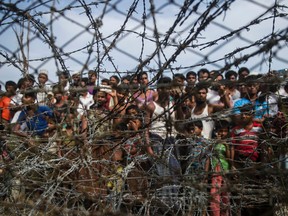 This picture taken from Maungdaw district, Myanmar's Rakhine state on April 25, 2018 shows Rohingya refugees gathering behind a barbed-wire fence in a temporary settlement setup in a "no man's land" border zone between Myanmar and Bangladesh.
Ye Aung THUYE AUNG THU/AFP/Getty Images