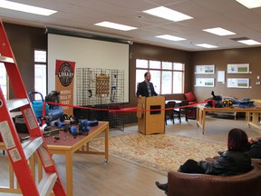 Canadian Tire general manager Chris Birch addresses the people assembled at the Cochrane Public Library on Saturday, April 21 as many of the tools now on loan are displayed in the foreground.