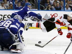 Tampa Bay Lightning defenceman Ryan McDonagh (27) sends New Jersey Devils left-winger Taylor Hall (9) flying after Hall shot against goaltender Andrei Vasilevskiy (88) during the third period of Game 5 of an their first-round NHL  playoff series last weekend in Tampa, Fla. (AP Photo/Chris O'Meara)