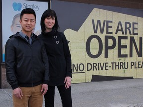 Supplied photo
Dentists Michael Liu and Melissa Stonley stand in front of Stonley Dental Studio, where temporary signage covers the location of a car accident that left a vehicle in the front waiting room in December 2017.