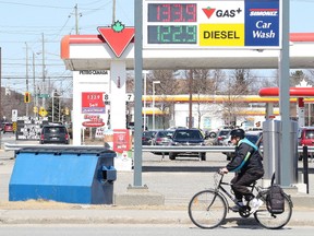 A cyclist rides past gas stations in Sudbury, Ont. on Thursday April 26, 2018. Analysts are predicting higher prices at the pumps for the summer.Gino Donato/Sudbury Star/Postmedia Network