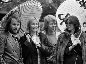 The four members of the Swedish pop group ABBA hold Japanese oil paper parasols in a light rain in the Japanese garden of their hotel in Tokyo in 1980. (Associated Press Photo)