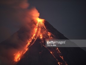 Mayon volcano emits lava cascading the slope as seen from Legazpi City, in Albay province, south of Manila on January 30, 2018. The threat of catastrophic mudflows is building on the slopes of an erupting Philippine volcano where nearly 90,000 residents have been moved out of harm's way, authorities said Tuesday. / AFP PHOTO / TED ALJIBE (Photo credit should read TED ALJIBE/AFP/Getty Images)
