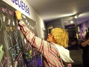 Justin Bieber signs a message board at the Stratford Perth Museum on Friday, April 27, 2018 in this handout photo. Justin Bieber's grandparents are known to frequent an exhibit on him in his hometown of Stratford, Ont. But on Friday the venue got an unexpected visit not just from them, but also from the pop superstar himself. (THE CANADIAN PRESS/HO, John Kastner)