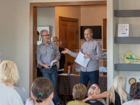 PHOTO SUPPLIED
President Dave McRae, left, with the Rotary Club of Grande Prairie, and raffle manager Kevin Hilgers, right, announce winners on April 26 at the Dream Home in Taylor Estates.