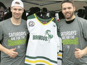 BRUCE BELL/THE INTELLIGENCER
Former Humboldt Bronco and County native Joey Davies (left) and Eric Hays pose with Daviesí sweater and tee shirts players received at the Heritage Classic in Demorestville on Saturday.