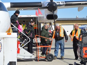 Timmins Victor M. Power Airport manager David Dayment assists a passenger during deplaning on Sunday afternoon. Brandon Spence, emergency coordinator for Kashechewan First Nation, said six flights carrying 350 people were scheduled to land in Timmins on Sunday, with more coming Monday. Fears of flooding prompted the community's evacuation, which will see 1,700 residents dispersed across Ontario during break-up. Stage 1 residents are the first to evacuate, including vulnerable people, families with young children, people with mobility issues or health issues and the elderly. Kapuskasing welcomed the first such residents on Thursday.