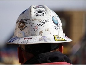 A worker wears a protective helmet decorated with stickers during a hydraulic fracturing operation at a gas well, near Mead, Colo. (Brennan Linsley | The Associated Press)