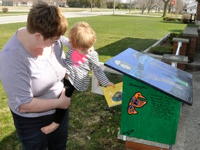 Jen Barr-Chalmers, and two-and-a-half year old daughter Della, pull out a book from their “little library” located in front of their house on St. George Street in Mitchell.  ANDY BADER/MITCHELL ADVOCATE