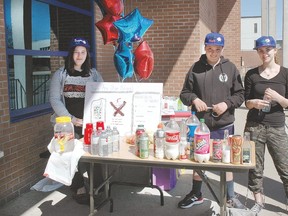 Keirston Belair, Myles Frech and Lucy Haman — volunteer leaders-in-training — set up shop at the YMCA on Sunday — National Healthy Kids Day — to share knowledge about sugar and healthy food choices. Bottles on the table, filled proportionately with sugar, represent how much sugar is in favourite beverages, including organic choices.  As an alternative they suggest fruit infused water, which the group gave out to participants in the day’s physical activities. The Y made prizes of free memberships, a week at summer day camp and a new bike, donated by Canadian Tire.
Allana Plaunt/Special to Sault This Week