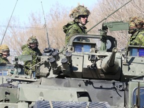 Soldiers from 1 Royal Canadian Regiment  Battlegroup, based out of Petawawa, wait atop a light armoured vehicle (LAV)  to pull into the armoury in Sudbury on Monday. The soldiers are on a 2,500-km driving exercise throughout Ontario for their upcoming deployment to Latvia. Gino Donato/Sudbury Star/Postmedia Network