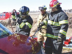 Vulcan firefighter Nancy Hansen and Cpt. Kevin Hansen work to disassemble a car at Vulcan’s transfer station during an advanced extrication course held April 20-21. Jasmine O'Halloran Vulcan Advocate