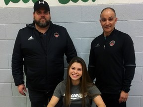 St. John's Olivia Pomponio signs her letter of intent to attend Lourdes University while head soccer coach (left) Jackie Donovona and Pomponio's father, Peter, look on.