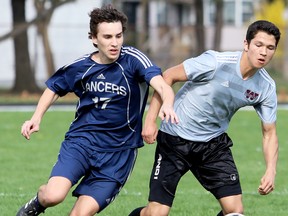 Ursuline Lancers' Kiano Sousa, left, challenges Wallaceburg Tartans' Colin Crow for the ball in the first half of an LKSSAA senior boys' soccer game at Ursuline College Chatham in Chatham, Ont., on Wednesday, May 2, 2018. (MARK MALONE/Chatham Daily News/Postmedia Network)