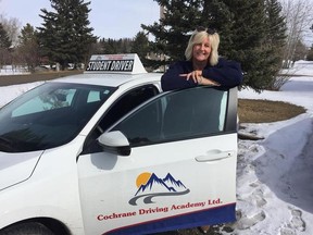 Debbie Sherwood poses with one of the fleet in the Cochrane Driving Academy before heading off to Saudi Arabia.