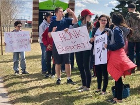 Students outside École du Sommet in St. Paul, Alta., hold placards on Thursday, May 3, 2018 in support of principal Yvan Beaudoin, who left his duties at the school on March 19 without an explanation from the school superintendent or the school board. Parents pulled their children from school at lunch hour to demand answers.
