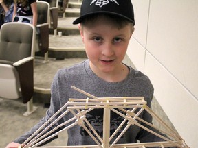 Aaron Harris holds his entry to Sault College and Professional Engineers Ontario - Algoma Chapter's 29th annual bridge building contest.