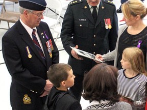 Capt. Roy Harten speaks with Karen Fenchak, daughter of Capt. Cliff Healey, her family and Healey's twin brother, Clyde, following a dedication ceremony.