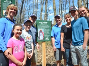 A trail was dedicated to the memory outdoorsman Doug Wardell Saturday on a wooded property south of Owen Sound. His family, pictured around a sign commemorating him, attended the ceremony. Derek Wardell and his wife Lori, and their kids Carly, 7, Zach, 10, are on the left, while Dave Wardell and his wife Dana and kids Dylan, 14, and Deanna, 16, are on the right. (Scott Dunn/The Sun Times)