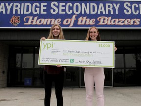 Reese Jamieson, left, and Katie Jackson stand in front of Bayridge Secondary School with their $5,000 cheque for the Salvation Army Kingston Citadel Community and Family Services on Thursday. (Wyatt Brooks/For The Whig-Standard/Postmedia Network)