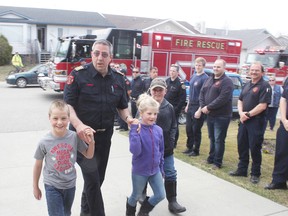 KEVIN RUSHWORTH HIGH RIVER TIMES/POSTMEDIA NETWORK. Len Zebedee, now former High River Fire Department (HRFD) fire chief, walks up his driveway with friends and family members present while local firefighters flank the drive on April 30. Members with the HRFD, Foothills Fire Department—including Cayley and Blackie halls—were on hand to surprise Zebedee, providing him his last ride home in Engine 42 alongside a parade of fire vehicles.
