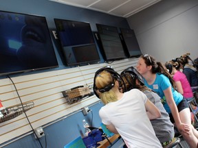 St. Columban student Jill Gaffney laughs after seeing her face displayed on the screen during the welding simulator session of a skilled trades workshop on Wednesday, May 2 in Mitchell. TERRY BRIDGE/POSTMEDIA NETWORK