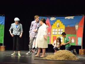 Kwiatkowski and Daye investigate the destruction of a house made of straw during the Pumpjack Players production on May 6.