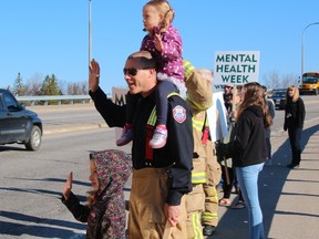 Sophie, 6, left, Dave and Adeline Morin, 3, were among those giving motorists a lift and a smile, Monday morning, at the Lakeshore Drive Overpass as part of the Beat the Monday Blues Morning Wave organized by the Canadian Mental Health Association. The event marked the beginning of the association's annual Mental Health Week activities.
PJ Wilson/The Nugget