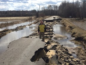 Woodlands County Mayor Jim Rennie stands on the remains of Flats Road, which suffered substaintial damage from the floods (Submitted | Jim Rennie).