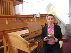 Jack Evans/For The Intelligencer
Matthieu Lattreille holds a copy of his first CD, recently released, as he sits on the organ bench in St. Thomas Anglican Church.