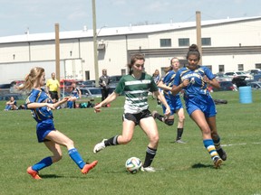 St. John's College girls soccer player Kaitlyn Overeem gets by a pair of Brantford Collegiate Institute defenders as she scores a goal during a Brant County high school game at WIFO Soccer Park in Paris on Monday. (Brian Smiley/The Expositor)