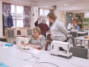 Karen — at the machine — among the women involved in Sault Ste. Marie’s Quilts for Kids campaign/charity, offers sewing tips to Sophie, who is learning to make a quilt for donation. The bee has  two more Wednesdays at Emmaus Anglican Church, 1643 Wellington St. E. The church has donated space and storage for the sewing machines and fabric.  The group is working on a pattern of alternate squares. This year, special quilts will go to families of the Humboldt Broncos. The women preferred to leave their last names anonymous.
Allana Plaunt/Special to Sault This Week