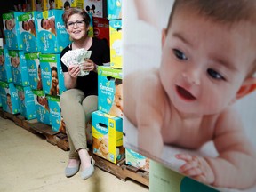 Luke Hendry/The Intelligencer
Bev Heuving of the Community Development Council of Quinte holds diapers in the council's storeroom Tuesday. Staff are hoping the public will donate 15,000 diapers during Wednesday's diaper drive. The council sells boxes of baby supplies at discounted prices as a public service.