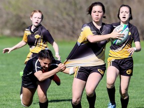 Blenheim Bobcats' Cora Nicholas is grabbed by Northern Vikings' Rana Ali in the second half of an LKSSAA senior girls rugby game at Blenheim District High School in Blenheim, Ont., on Tuesday, May 8, 2018. The Vikings won 19-14. (MARK MALONE/Chatham Daily News/Postmedia Network)
