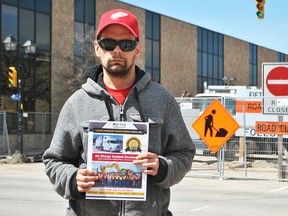 Chatham resident Matthew Schaub holds up a booklet about a heavy equipment operator program, at the corner of King Street West and Fifth Street. The 28-year-old says he has not been able to find financial assistance to enter the program. Tom Morrison/Chatham This Week