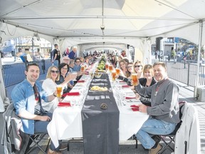 Diners toast at the start of the Canmore Uncorked Long Table dinner event under a tent in front of the Canmore Civic Centre plaza on Thursday, May 4, 2017. Pam Doyle/. pamdoylephoto.com