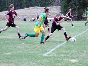 Canmore Collegiate High School Crusaders' Malcolm Rogers (centre) chases the ball during a Foothills Soccer League game against Okotoks' Foothills Collegiate Falcons at Millennium Park in Canmore on Monday, May 7, 2018. Foothills won 4-3. Russ Ullyot/ Bow Valley Crag & Canyon/ Postmedia Network