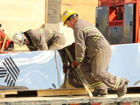 Brandon Charbonneau, left and Scott Horneland secure the top half of the sports structure to a flatbed truck outside Revolution Place on Wednesday in Grande Prairie. It had to be taken in for repairs. Joshua Santos/Daily Herald-Tribune.