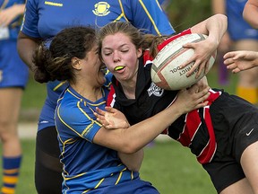 BCI's Kaia Grant (left) stops Paris District High School ball carrier Emilee Dobson during the high school junior girls rugby final on Wednesday in Paris. (Brian Thompson/The Expositor)