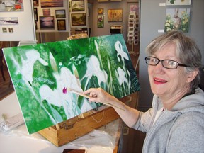 Artist Kit Cutting works on a painting of irises in the newly reopened Portside Gallery, which holds an open house Saturday after flooding forced a late-February closing. (Eric Bunnell/Times-Journal)