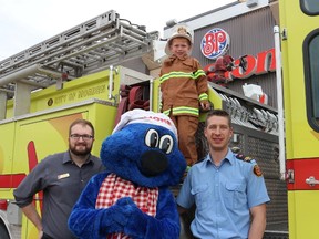 Boston Pizza general manager Mike Rose, Lionel and Captain Jonathan Baumgart helped Aaron Schulz celebrate being fire chief for the day. (LAUREN MACGILL, Morden Times)