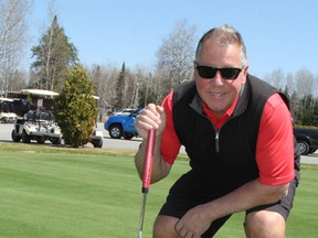 Keith Grenke, general manager of Spruce Needles Golf Club, lines up a shot during a practice putt on one of the greens. Spruce Needles is set to open for the season today.